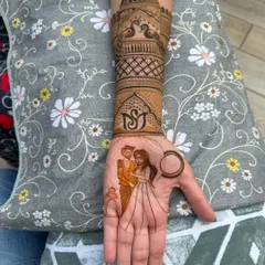 A perfect example of combining personal stories with traditional art. This design features a custom couple portrait on the palm, complemented by a beautiful architectural design on the arm with peacocks and custom initials.