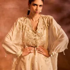 Our ORION Kaftan Set in ivory, where phoenix-inspired motifs and pearl-infused tassel details create an exquisite ensemble.