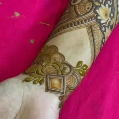 A close-up of a wrist cuff design. The pattern is geometric and modern, showing the versatility of henna art.