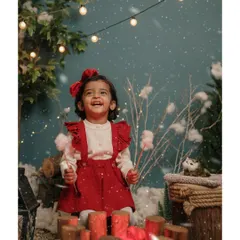 Pure Christmas joy! A little girl in a festive red outfit laughs with delight in our cozy, rustic "Winter Cabin" set.
