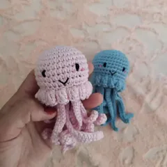 Holding the pink jellyfish to show its size relative to the blue one. I can make them as tiny charms or larger plushies.