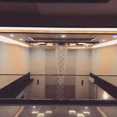 Looking down from the first-floor landing, you can appreciate the full impact of the double-height ceiling and the cascading chandelier. The glass railing ensures an unobstructed view.