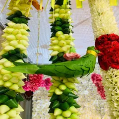 An example of our intricate craftsmanship. This parrot is skillfully crafted from green leaves and is often used as a beautiful, auspicious detail in our floral garlands and backdrops.
