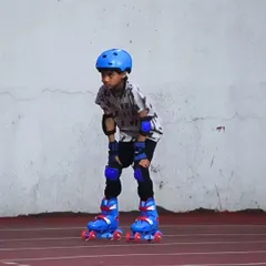 Focus and determination on wheels. This young skater is fully equipped with safety gear, concentrating on his posture and glide during a practice session on our Nerul track.