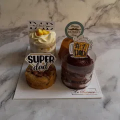 This Father's Day assortment platter comes with fun, themed toppers. The set includes a Mango Vanilla Cake, Date Walnut Tea Cake, a gooey cookie, and a decadent chocolate cake.
