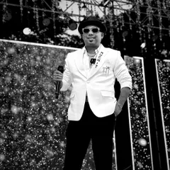 A classic black and white shot of me on stage, mic in hand. The custom jacket and confident stance reflect my professional persona as a corporate emcee, ready to take control of any event.