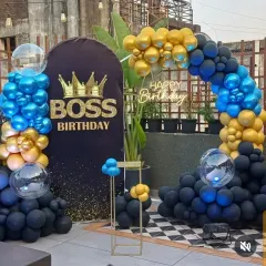 For this "Boss Birthday" on an office terrace, I used a bold color scheme of royal blue, black, and gold balloons. The custom printed backdrop with a crown graphic makes it clear who the celebration is for.