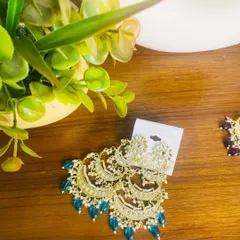 The same stunning tiered chandbali design, this time with teal-colored beads. This is a great option if you want to add a unique jewel tone to your ethnic wear.