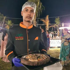Freshly baked pizza served with a smile at an outdoor celebration. Our live pizza station is perfect for adding a fun, casual touch that guests of all ages enjoy, from pre-wedding parties to birthday celebrations.