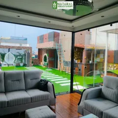 A view from inside the glass house, looking out onto the beautifully landscaped terrace in Shahdara.