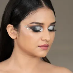 A close-up beauty shot showcasing a dramatic silver eye makeup look with crystal embellishments. This type of detailed work is ideal for makeup artists' portfolios and cosmetic campaigns.
