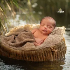 A modern-day Moses basket scene, created safely in our studio. We love crafting unique concepts like this, where your newborn appears to be floating peacefully, creating a truly artistic portrait.