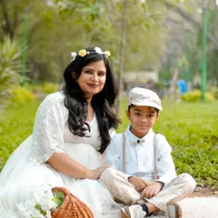A sweet mother and son portrait taken during an outdoor family maternity session. A picnic setup in the park creates a relaxed and charming atmosphere for capturing precious family bonds.