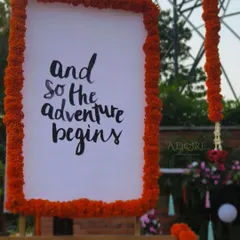 "And so the adventure begins." A simple, heartfelt sign framed with marigolds sets the perfect tone for the start of a new chapter. We love creating signage that tells your story.