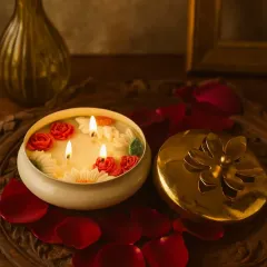 My Timeless Urli Candle, lit and glowing. The three wicks create a warm, inviting ambiance, while the hand-crafted wax roses and daisies add a touch of elegance. It’s perfect for festivals or making any evening feel special.