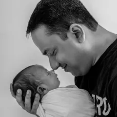 A powerful black and white portrait capturing the first bond between a father and his newborn. The gentle nose-to-nose touch is a simple yet deeply emotional expression of love.