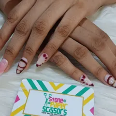 Showing off some intricate design work on these stiletto nail extensions. This set combines a sheer pink base with deep red abstract lines and dot work for a unique, artistic style.