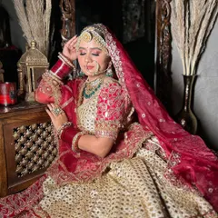 This off-white and red bridal lehenga offers a beautiful contrast. The intricate work on the skirt combined with the classic red dupatta creates a timeless bridal look.