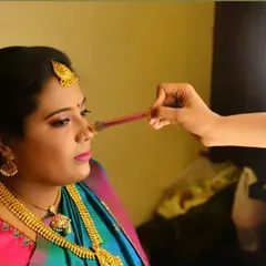 An action shot showing how I work. Using professional brushes and lighting, I am contouring the nose to add definition and ensure the makeup looks flawless from every angle and in all photos.