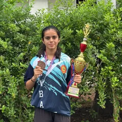 One of our star players, Nischitha, holding her bronze medal and the team trophy. We celebrate individual contributions that lead to team success.
