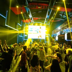 A wide shot of the dance floor at the Finnable tech corporate party. The combination of yellow spotlights and a massive LED screen creates a concert-like feel, proving that corporate gigs can be epic.