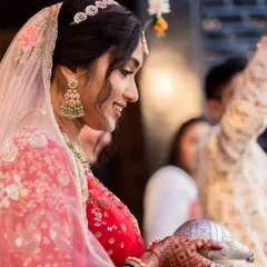 The gentle smile of a bride beginning her new journey. Her traditional jhumkas and sheeshpatti add a touch of timeless grace to her look.