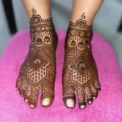 A geometric foot mehandi with a central diamond pattern featuring an elephant motif, surrounded by intricate line and dot work.