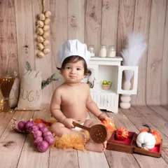 When the chef is this cute, who cares about the food? This little one is cooking up some smiles in our mini-kitchen setup, complete with tiny vegetables and a wooden spoon.