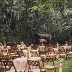 The guest seating was arranged among the trees, with simple wooden chairs and tables dressed in burlap. This rustic-chic setup created a warm and inviting atmosphere that felt perfectly integrated with the natural garden venue.