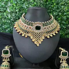 This stunning green and gold kundan choker set is a popular rental choice for mehendi or reception events. The set includes a broad necklace and heavy jhumkas, all adorned with emerald-green stones.