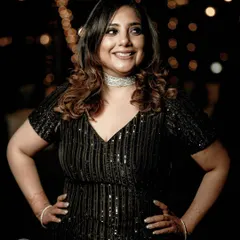 A confident and happy portrait of a guest at a cocktail party. The bokeh from the background lights adds a festive and glamorous feel to this candid shot.