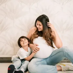 An expectant mother and her son share a happy moment, both looking forward to the new arrival.