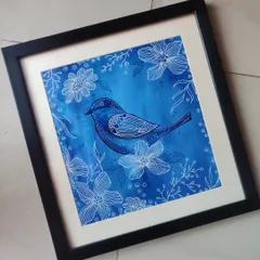 This framed piece, 'Blue Birdie', combines a rich blue watercolor background with intricate white floral line art. The detailed patterns on the bird make it a standout piece of decor.