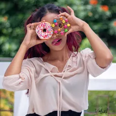 'Peek A Boo!' Using colorful donuts as playful props for a fun and sweet portrait. This kind of shoot is perfect for capturing a joyful and lighthearted personality.