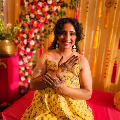 A happy bride showing off her minimal wedding henna. The design focuses on a beautiful mandala on each palm.