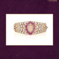 A blend of bold beauty and timeless charm. This handcrafted kada (bangle) features Polki diamonds and vibrant ruby-pink accents around a beautifully carved center stone. It's a piece designed to stand out.