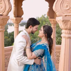 An intimate moment captured during a pre-wedding shoot. The couple's coordinated outfits, a blue lehenga and an ivory sherwani, were chosen to create a visually harmonious portrait that feels both grand and personal.