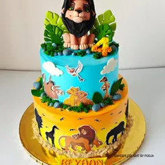 Hakuna Matata! This two-tier Lion King cake was made for a 4th birthday, featuring a hand-sculpted Scar topper and edible images of Simba and friends against a sunset savanna backdrop.