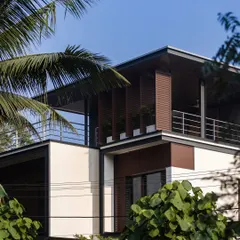 Exterior views of the Mango Tree Yard home, highlighting its contemporary form, clean lines, and the use of screens for privacy and ventilation.