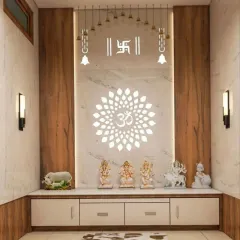 A modern pooja unit defined by its clean lines and powerful symbolism. The design features a large, backlit Om mandala on a white marble-finish backdrop, flanked by wood panels. Hanging bells and Swastik symbols add traditional touches to this elegant space.