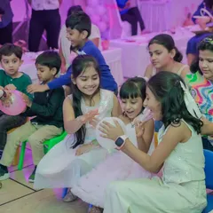 The same beautiful moment of children playing and laughing together, a testament to a successful and joyous party atmosphere.