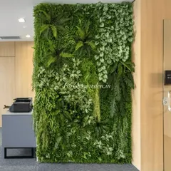 A lush vertical garden installed in an office corridor, featuring a mix of ferns and broadleaf plants. It's a great way to bring the calming effects of nature into the workplace without any upkeep.