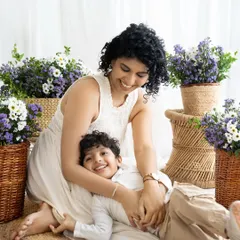 A playful and candid moment between mother and son. Lying on a soft rug, they share a laugh, capturing the fun and easygoing nature of their bond.