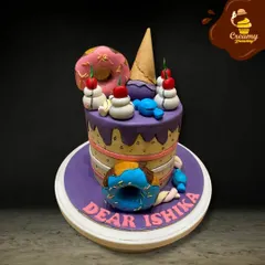 A dream cake for anyone with a sweet tooth. This design is overloaded with fondant treats, including donuts, an ice cream cone, and candies, all on a colorful purple cake.