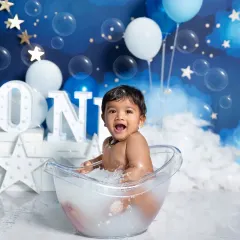 Pure joy during a first birthday bath splash! This add-on session captures the happiest moments as your baby plays in the water against a dreamy, starry night backdrop.