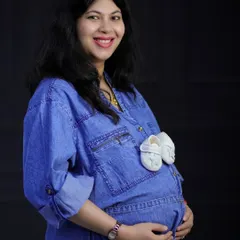 A playful and cute way to announce the baby's arrival. A tiny pair of white baby shoes are tucked into the pocket of this mom-to-be's denim shirt.