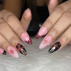 For when you're feeling moody and glam. This set features a mix of trendy tortoise shell nail art, deep red French tips, and delicate 3D floral accents on sharp stiletto extensions.