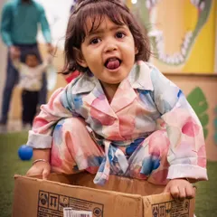 A playful moment from a preschool carnival. Capturing the personality of each child, like this little girl's cheeky expression, is what makes event photography so special.