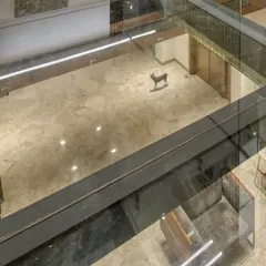 An overhead view of the glass bridge, showing how it creates a visual connection to the floor below while maintaining an open and airy feeling.