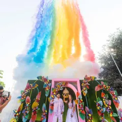 Love paints the sky in all its colors. A rainbow of smoke bombs created a spectacular and photogenic moment for this couple during their outdoor carnival celebration.